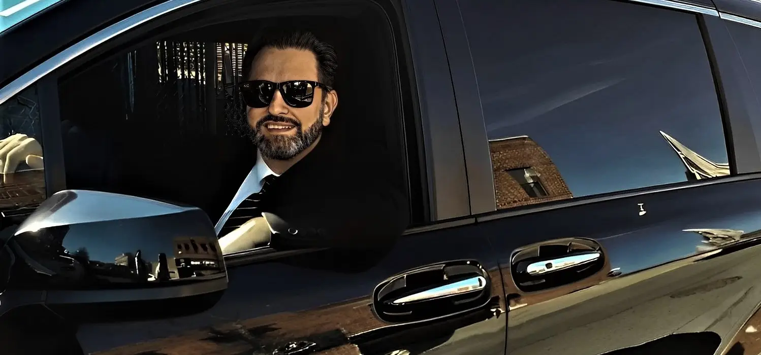 Legends Limousine NYC Car and Limo Service Chauffeur Smiling in Car Service Limo Driving Through New York