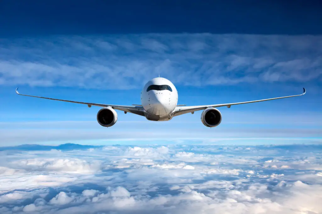White Passenger Airplane in the sky following airport takeoff